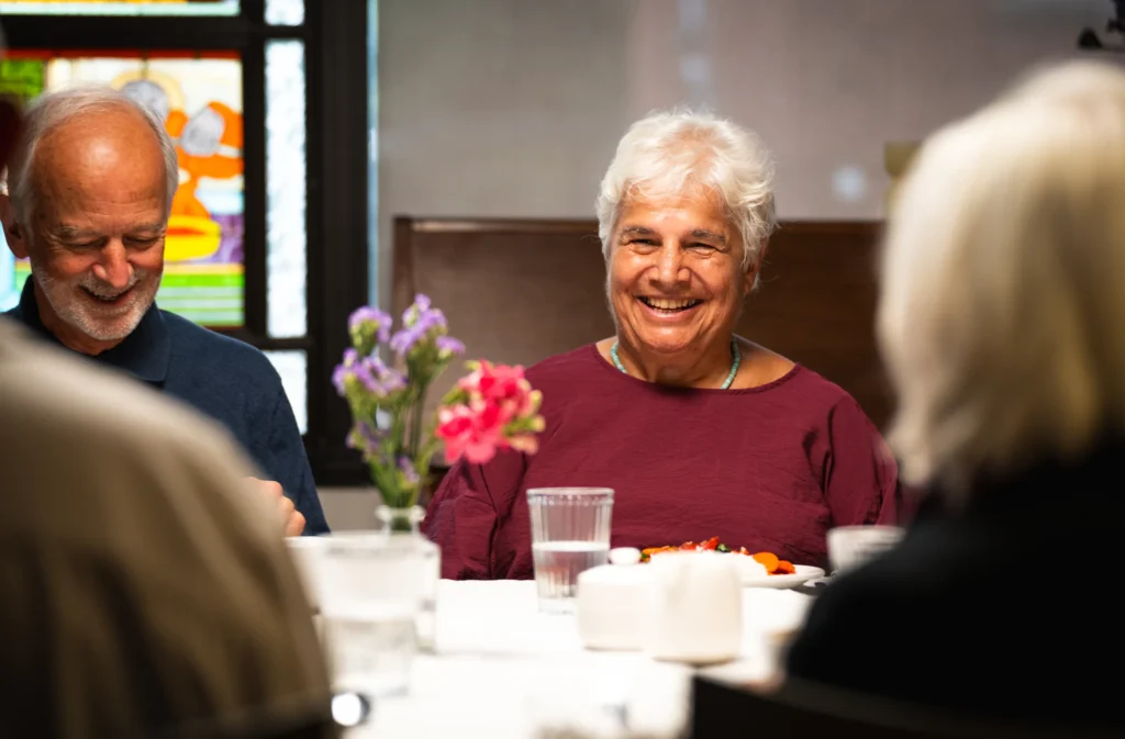 Residents laughing together over a meal