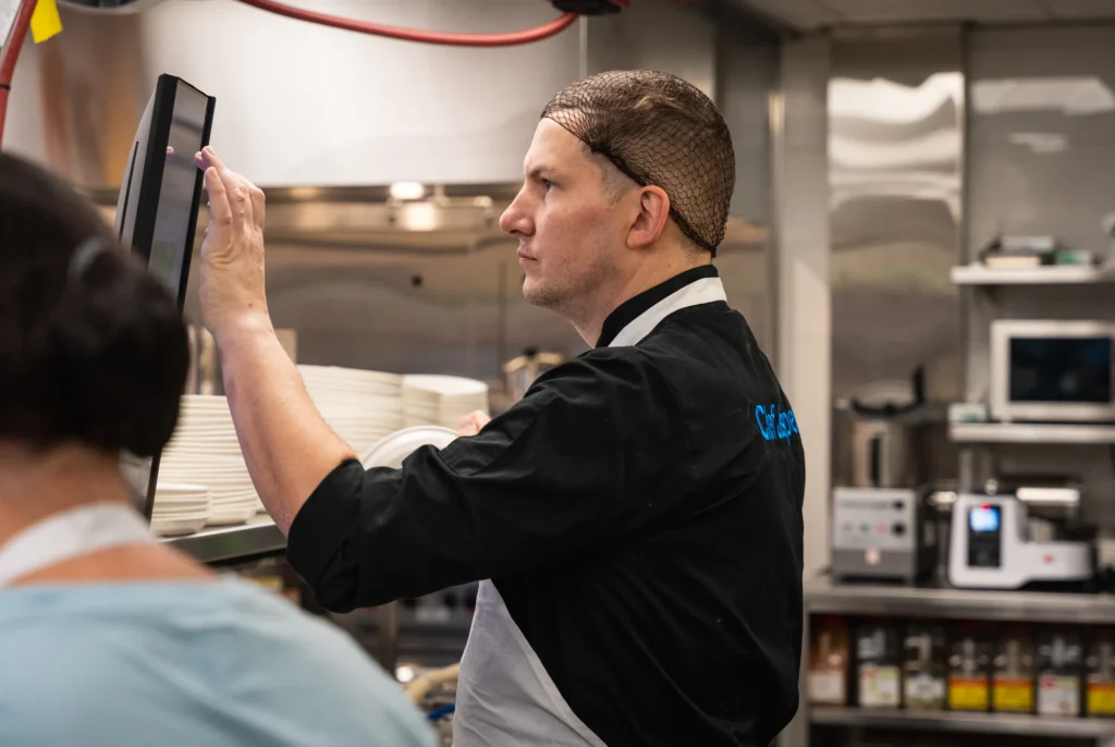 Chef Jasper cook checking a digital workstation screen in the kitchen