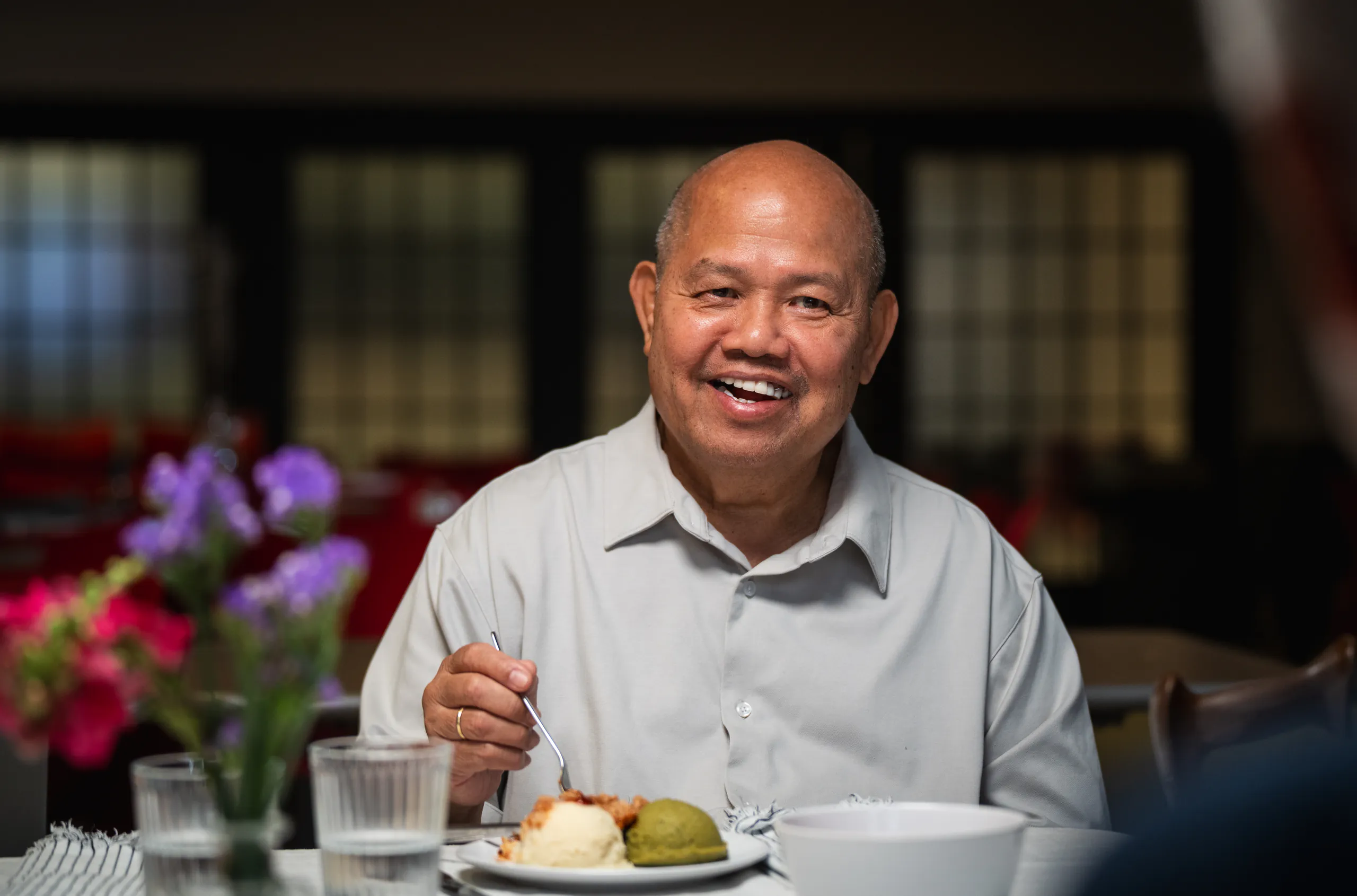 A long-term care resident smiling over a plated meal