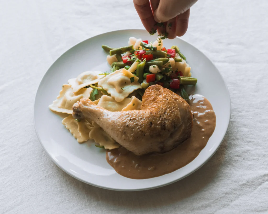 Cuisses de poulet Stroganoff à la crème et aux champignons, ravioli au fromage et légumes de saison